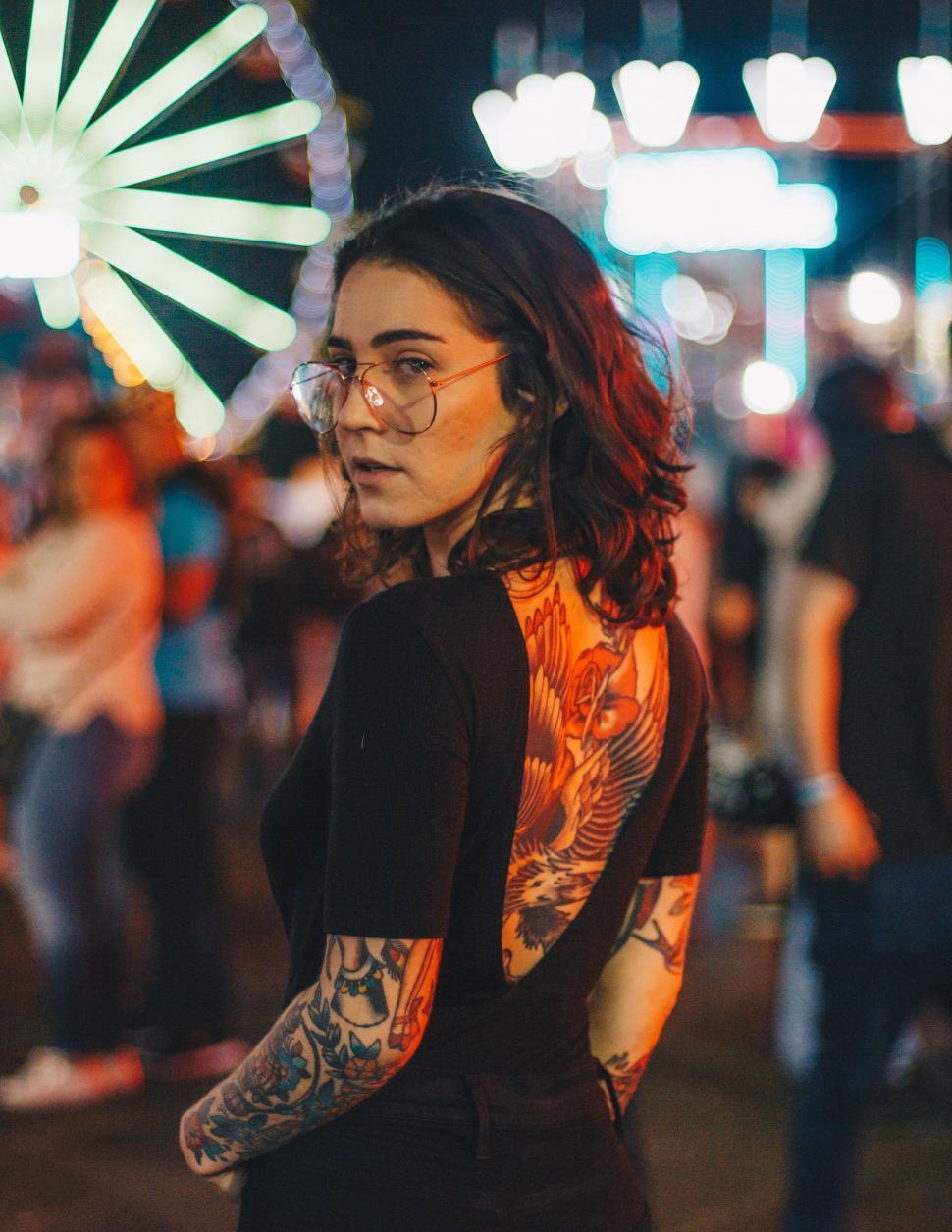 Free Image of Tattooed woman at night festival 