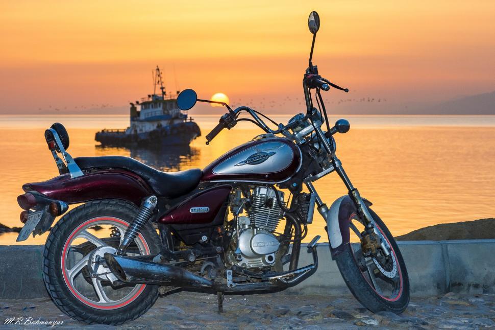 Free Image of Motorbike against a seaside sunset backdrop 