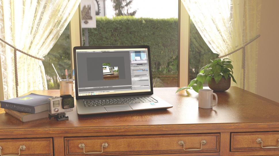 Free Image of Sunny home office with laptop and photography books 