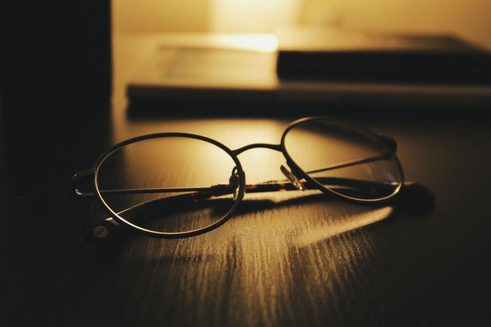 Free Image of Eyeglasses on a table in dim light 