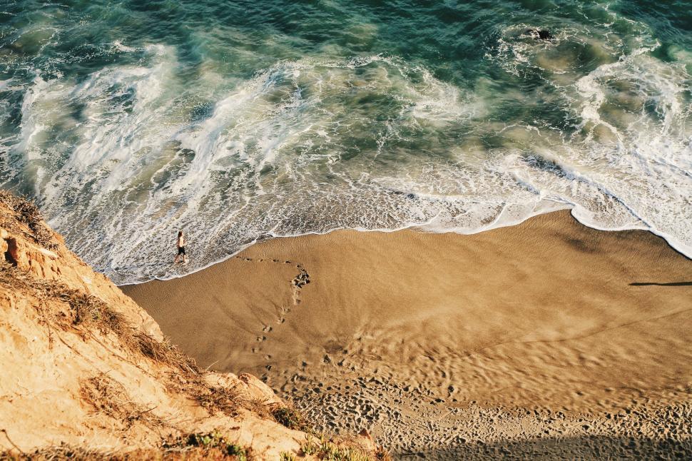 Free Image of Aerial beach view with waves and single person 