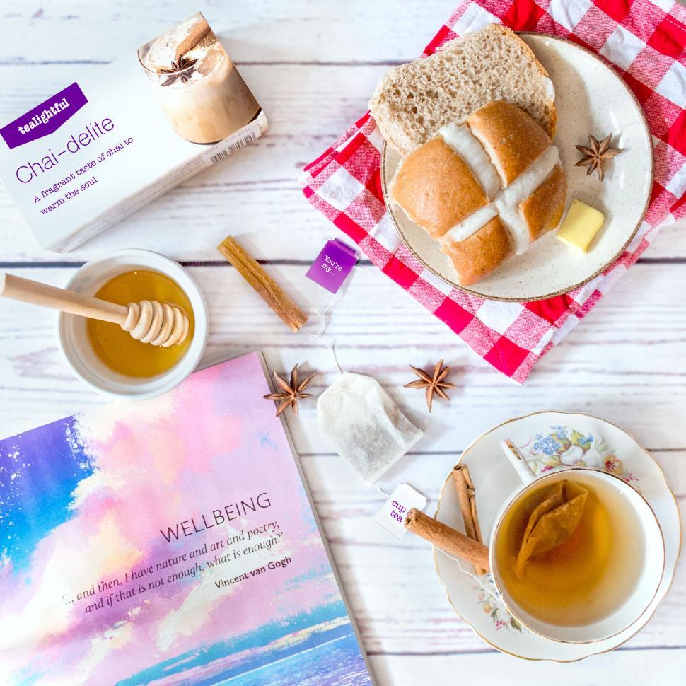 Free Image of Tea time with bread, honey, and a book 