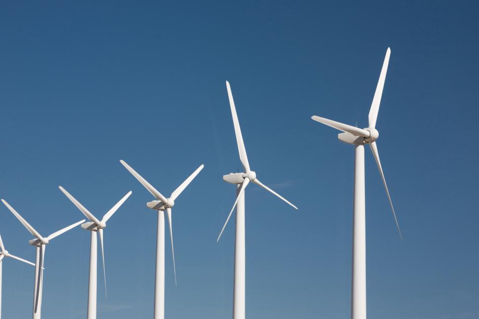 Free Image of Row of Wind Turbines Against Blue Sky 