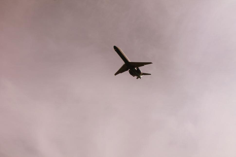 Free Image of Airplane silhouetted against cloudy sky 