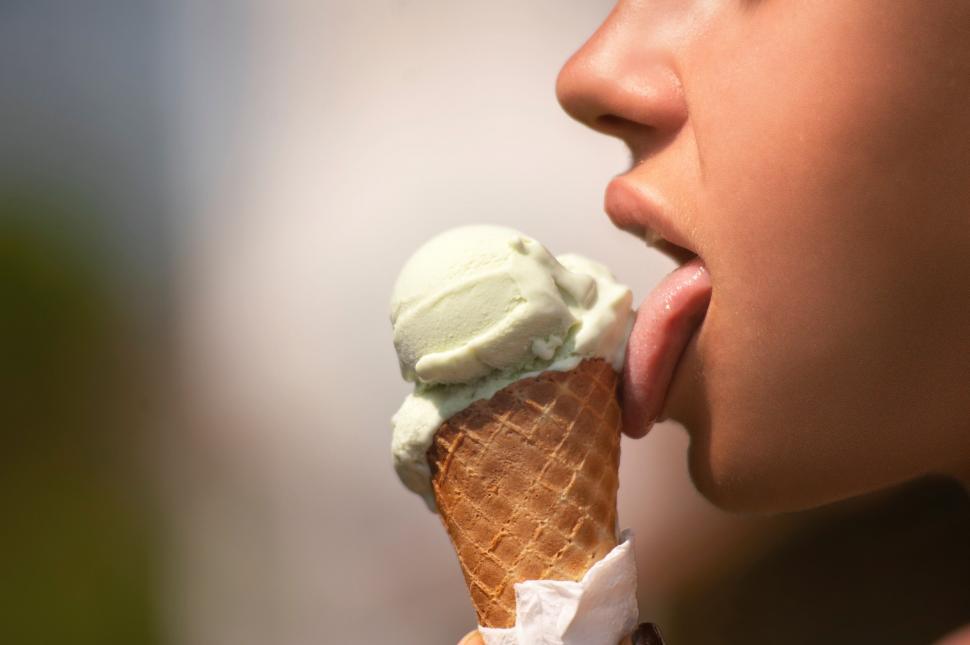 Free Image of Ice cream cone held against a blurred background 