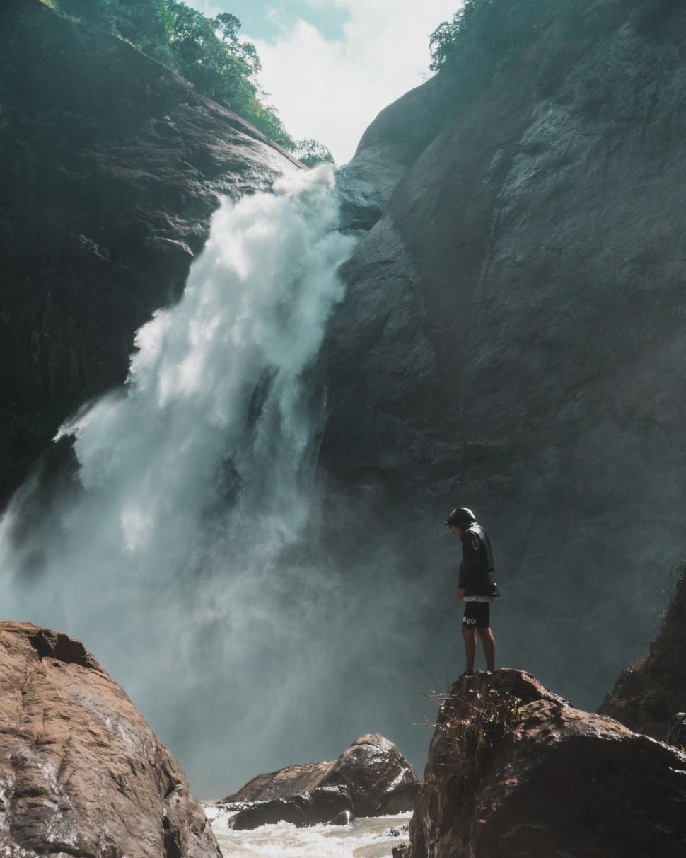 Free Image of Hiker observing powerful waterfall 