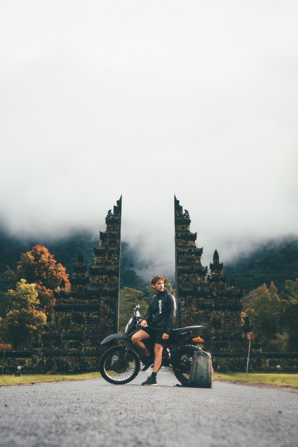 Free Image of Motorcyclist pausing on a misty mountain road 