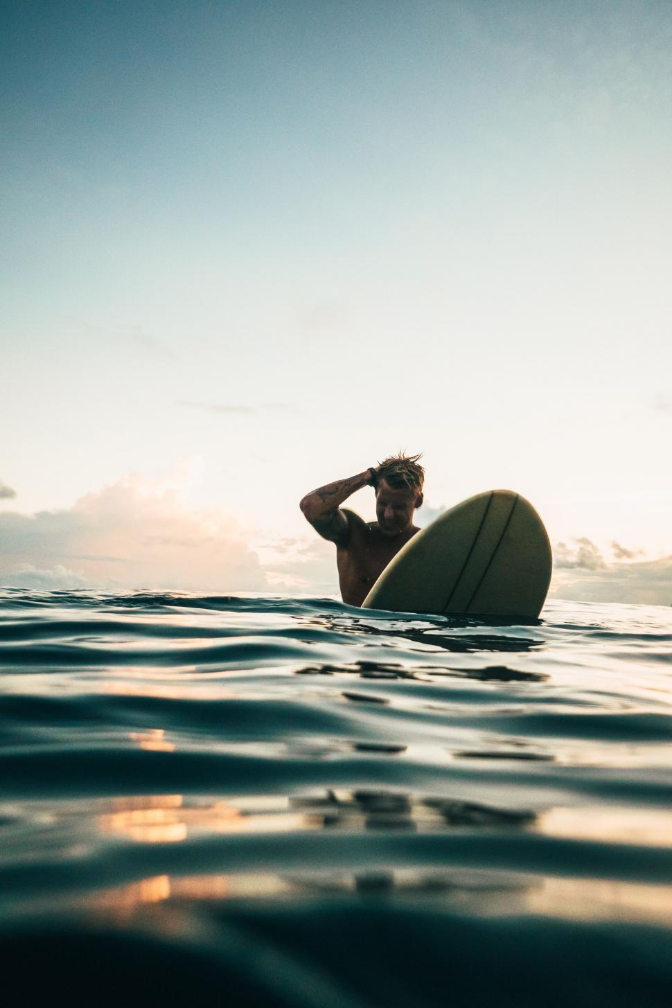 Free Image of Surfer contemplating ocean at sunset 