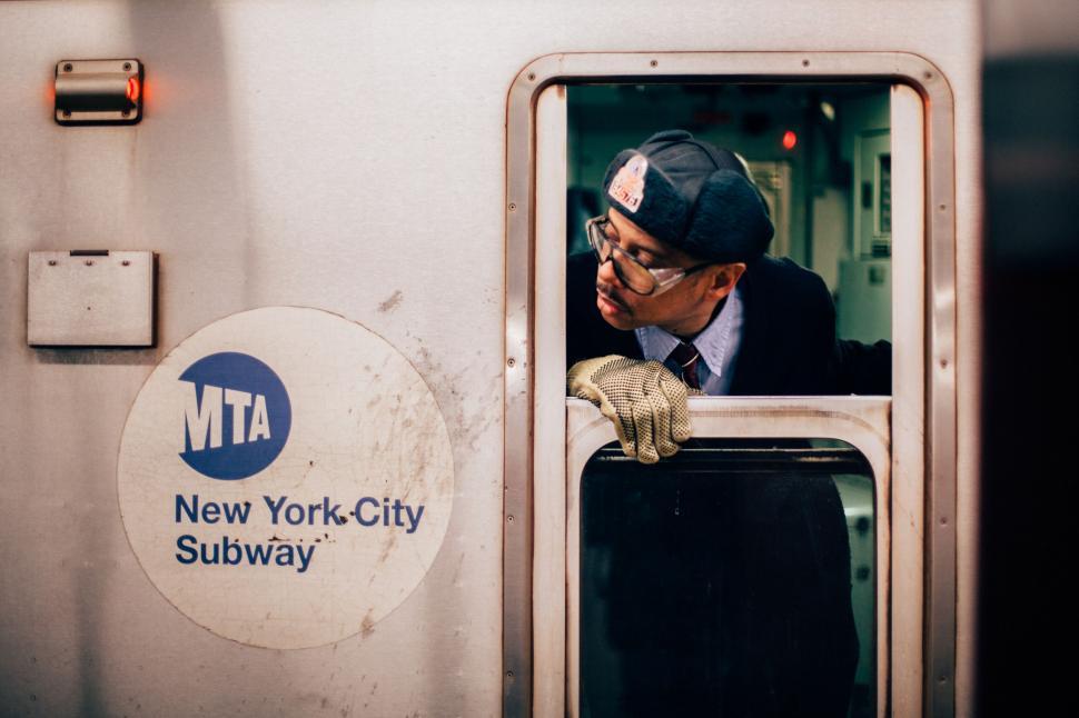 Free Image of Subway worker leaning out train door 