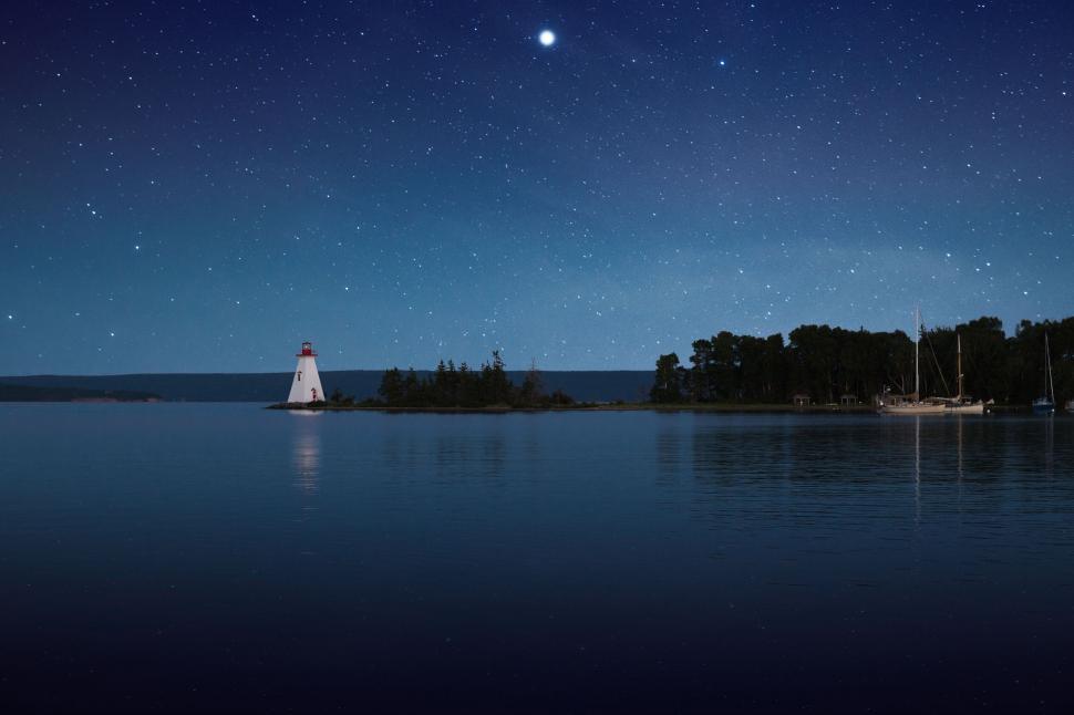 Free Image of Serene lighthouse and stars over calm lake 