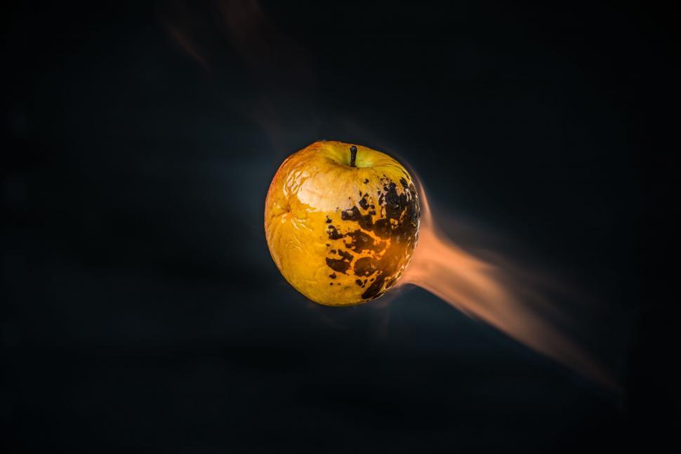 Free Image of Flaming apple floating in dark space 