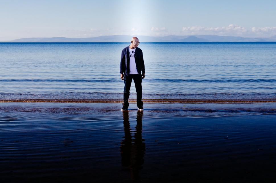 Free Image of Man gazing at the sea in a serene setting 