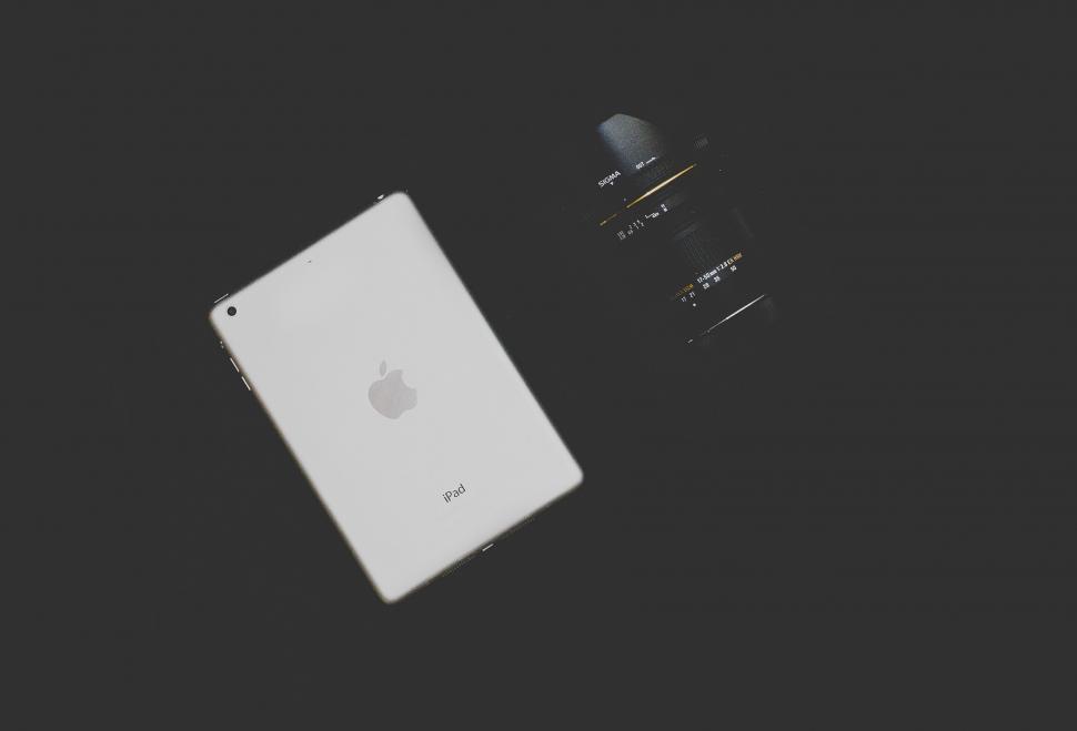 Free Image of iPad and camera lens in a dark setting 