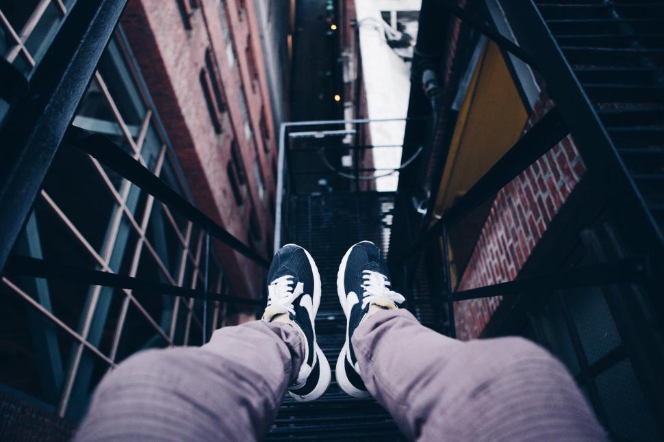 Free Image of Person standing on metal fire escape 