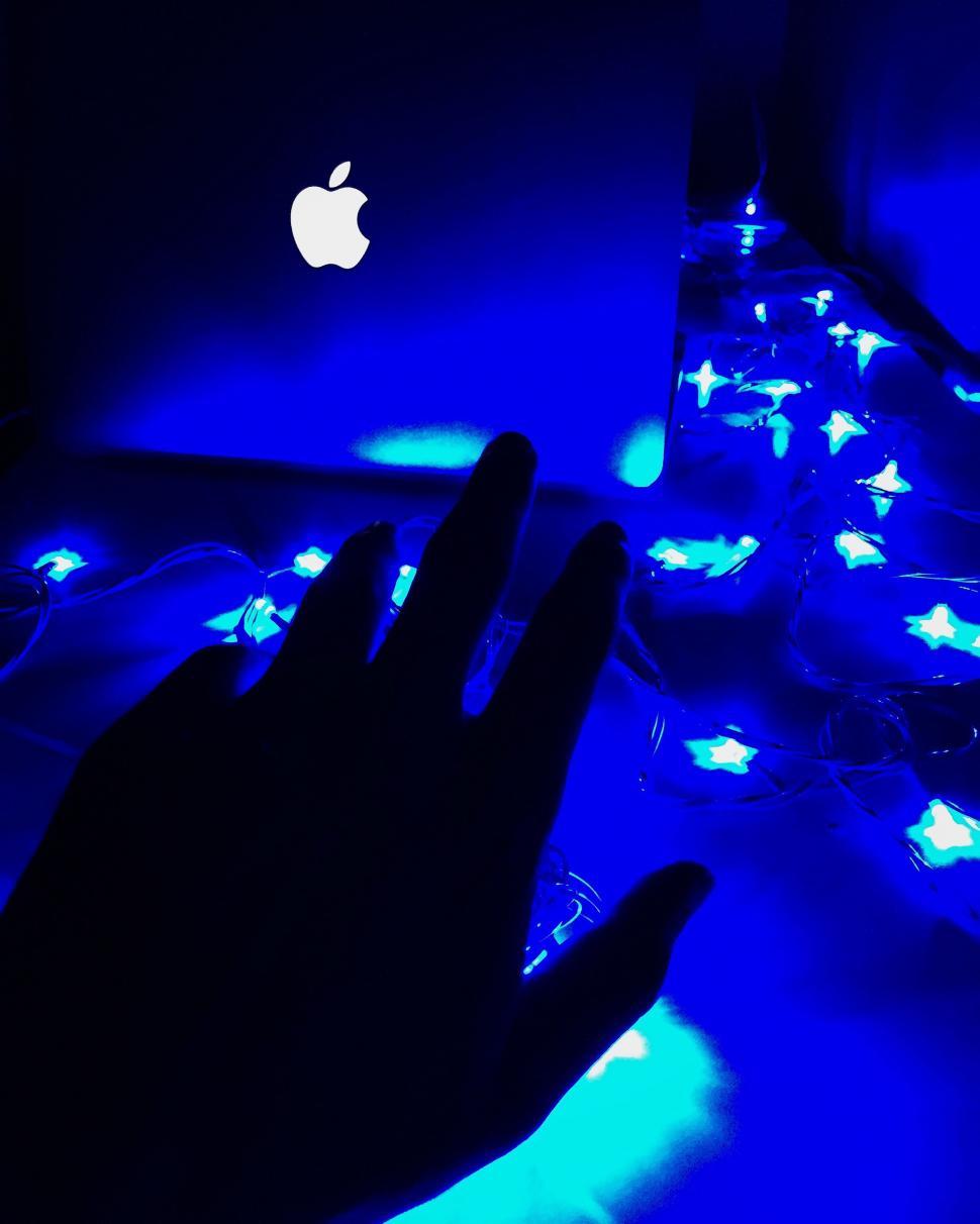 Free Image of Blue illuminated laptop and hand 