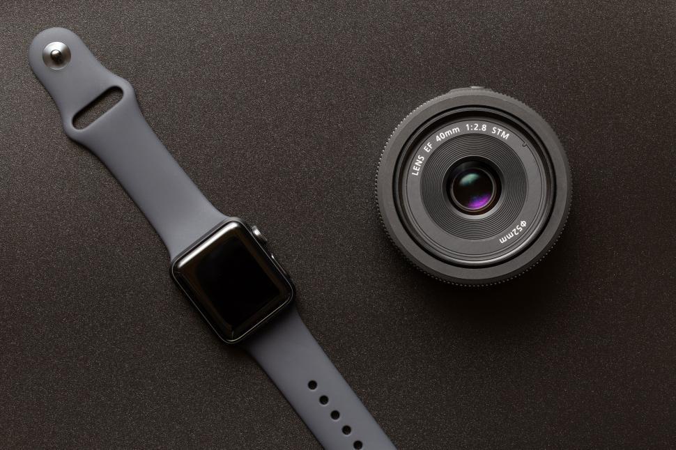 Free Image of Smartwatch and camera lens on neutral background 