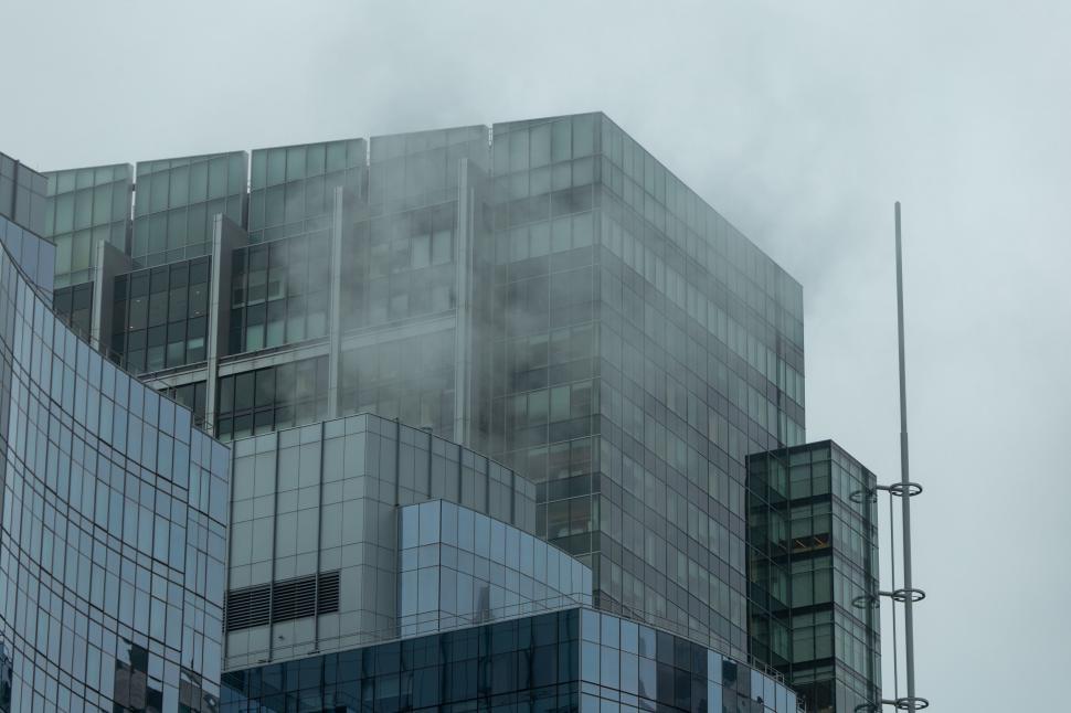 Free Image of Modern skyscraper shrouded in misty clouds 
