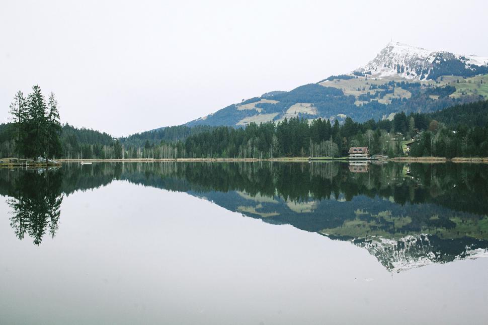 Free Image of Calm lake with mountain reflection in background 