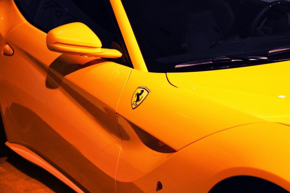 Free Image of Yellow Ferrari supercar with logo close-up 