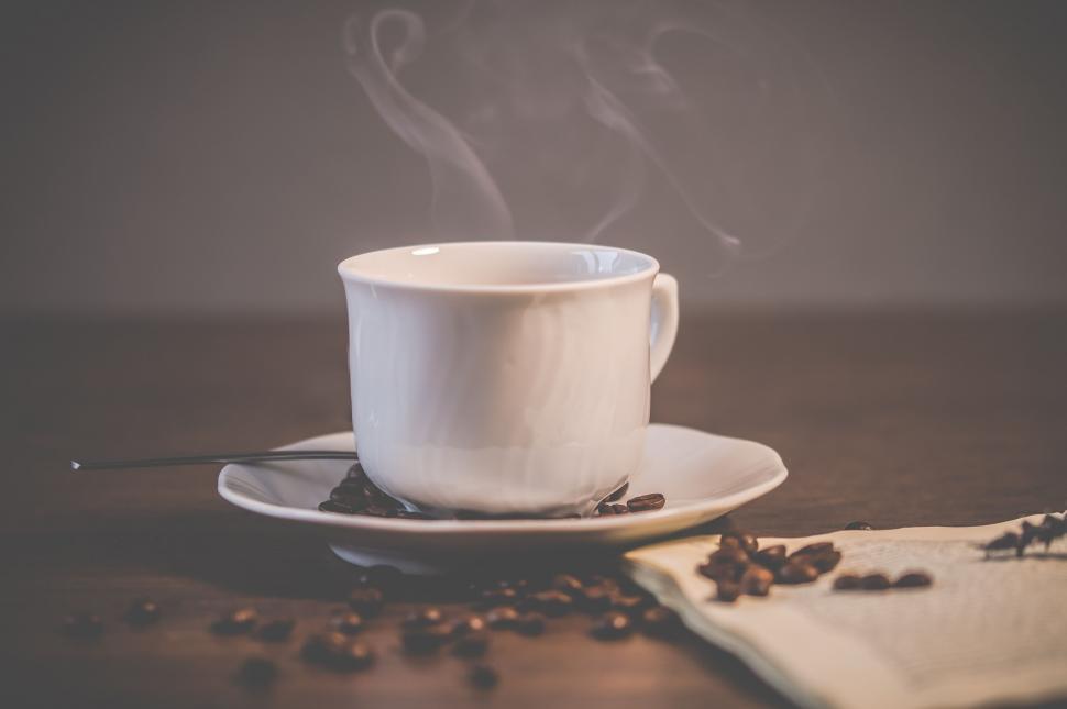Free Image of Steaming coffee cup with saucer and spoon 