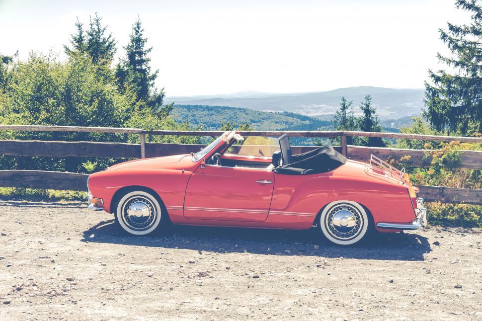 Free Image of Classic red convertible car on mountain road 