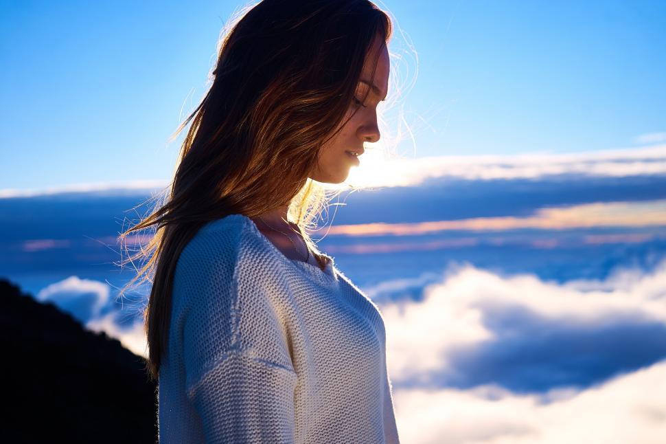 Free Image of Back view of person facing clouds at sunrise 