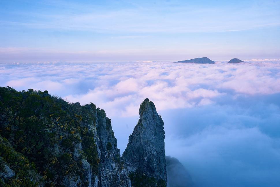 Free Image of Mountain peaks emerging above clouds 