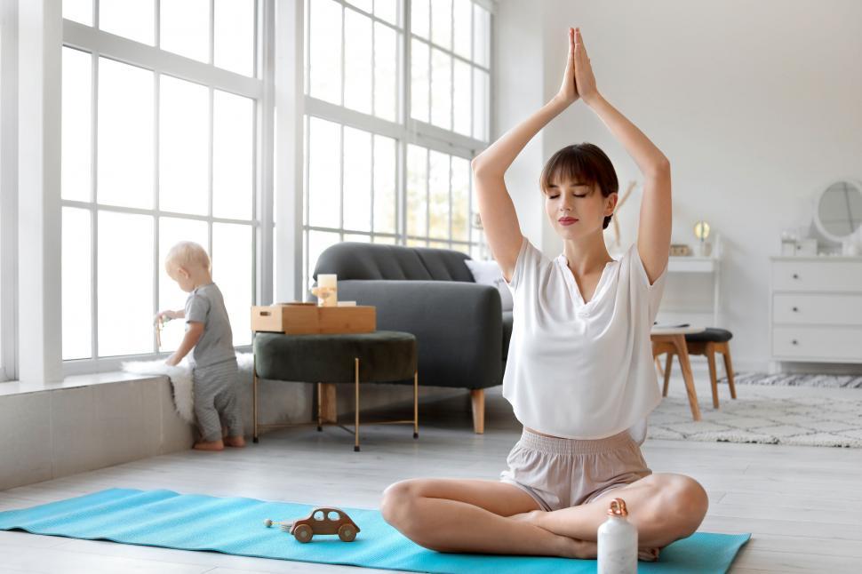 Free Image of Woman in meditation with child in the background 