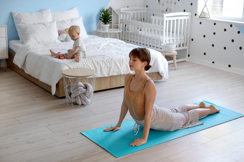 Free Image of Mother doing yoga with child on yoga mat 