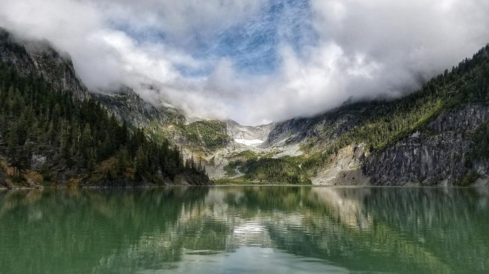 Free Image of Serene mountain lake with overcast skies 
