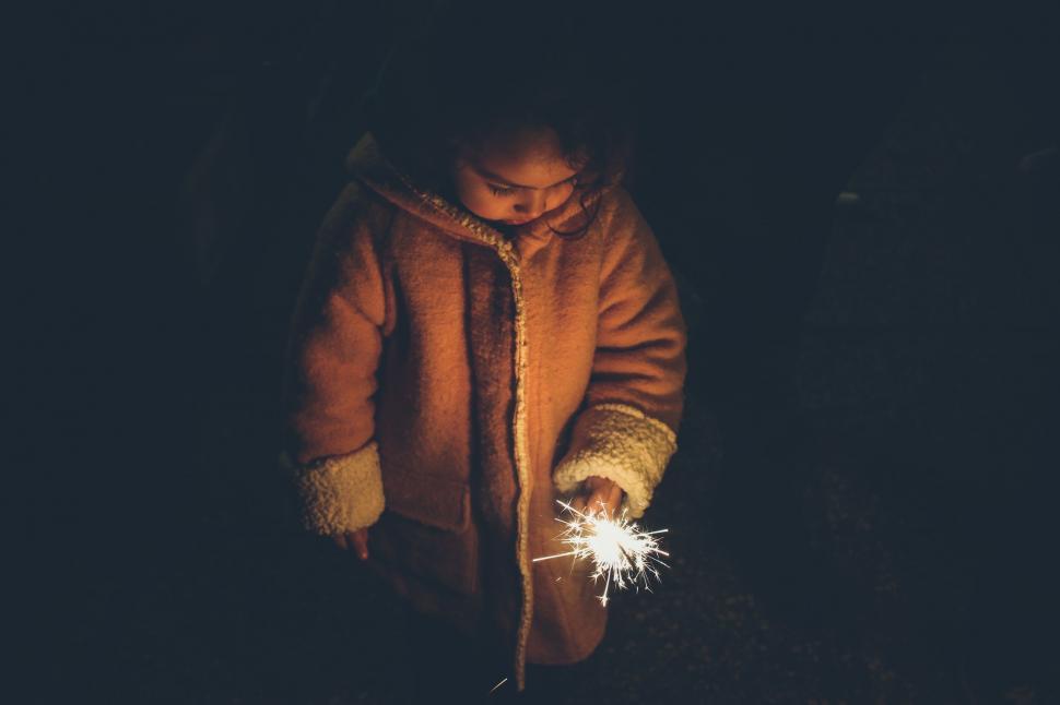 Free Image of Child holding a sparkler in darkness 