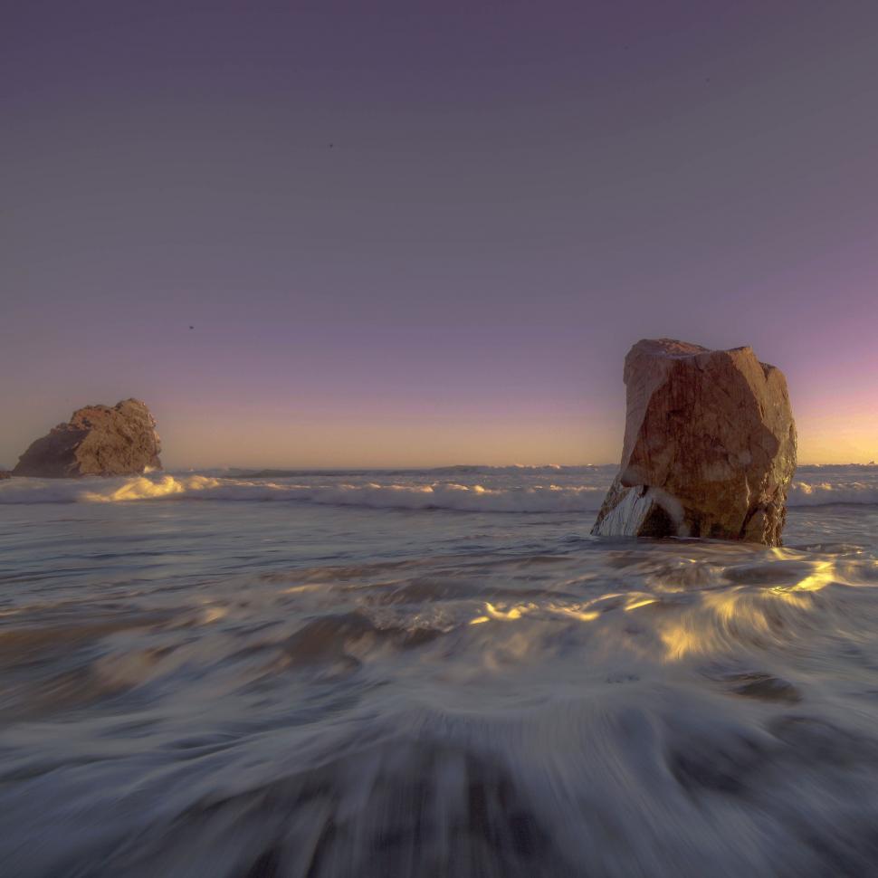 Free Image of Rock formations in ocean at sunset 