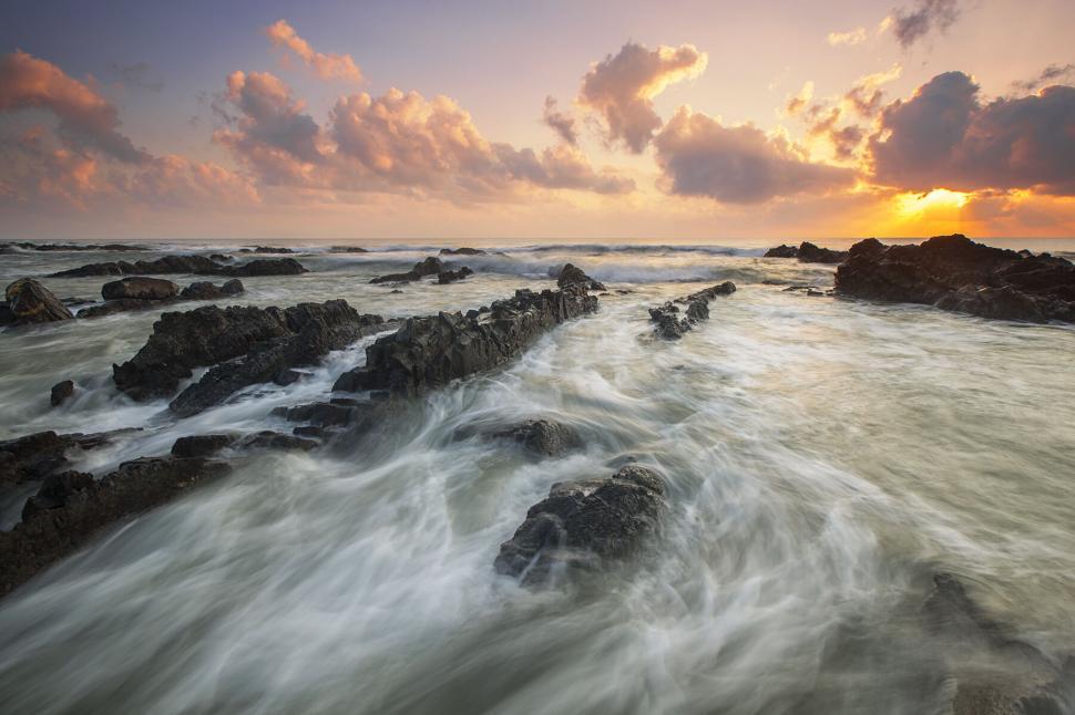 Free Image of Rugged rocks against a vibrant sunset sky 
