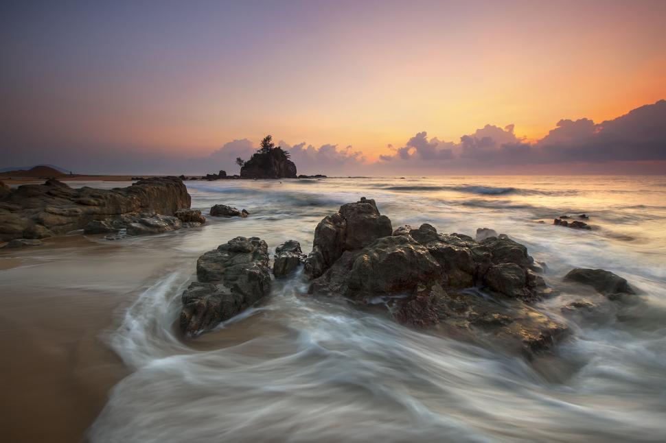 Free Image of Soft ocean waves over rocks at sunset scenery 
