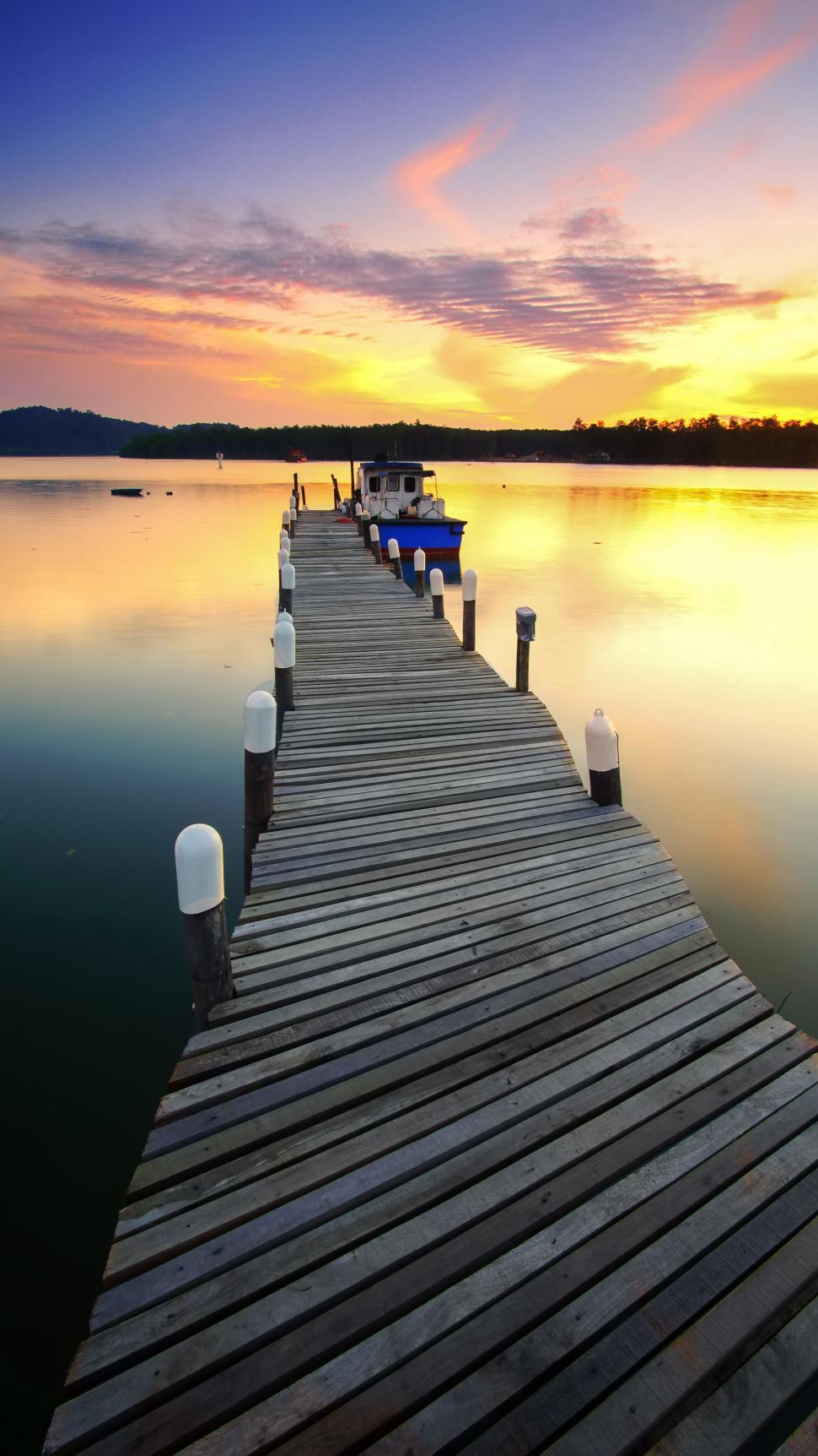 Free Image of Wooden jetty on a calm lake at sunset 