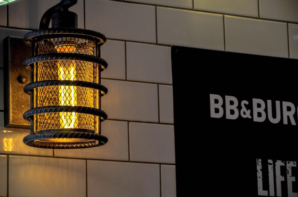 Free Image of Illuminated hanging lamp near a restaurant sign 