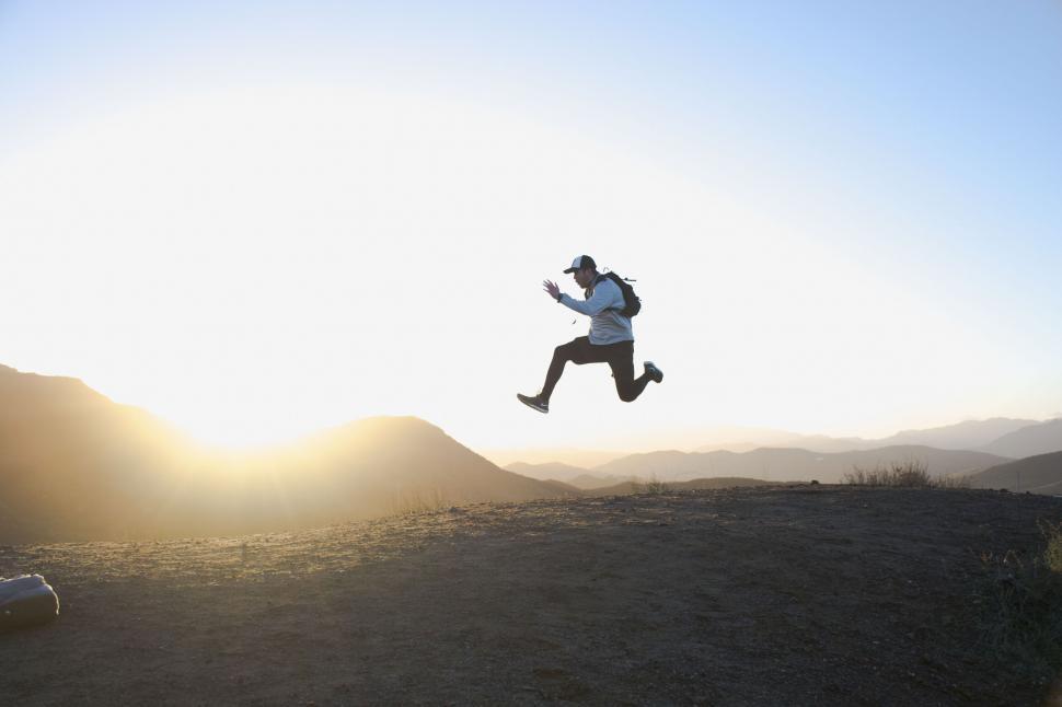 Free Image of Person jumping in front of sunrise 