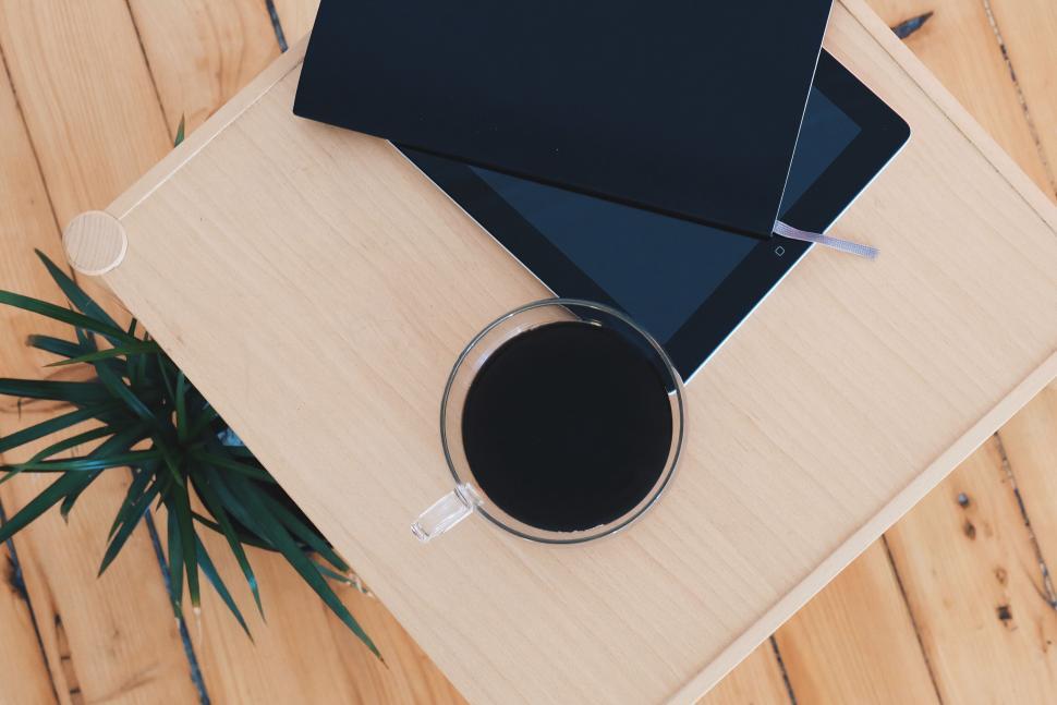 Free Image of Tablet and coffee cup on wooden table 