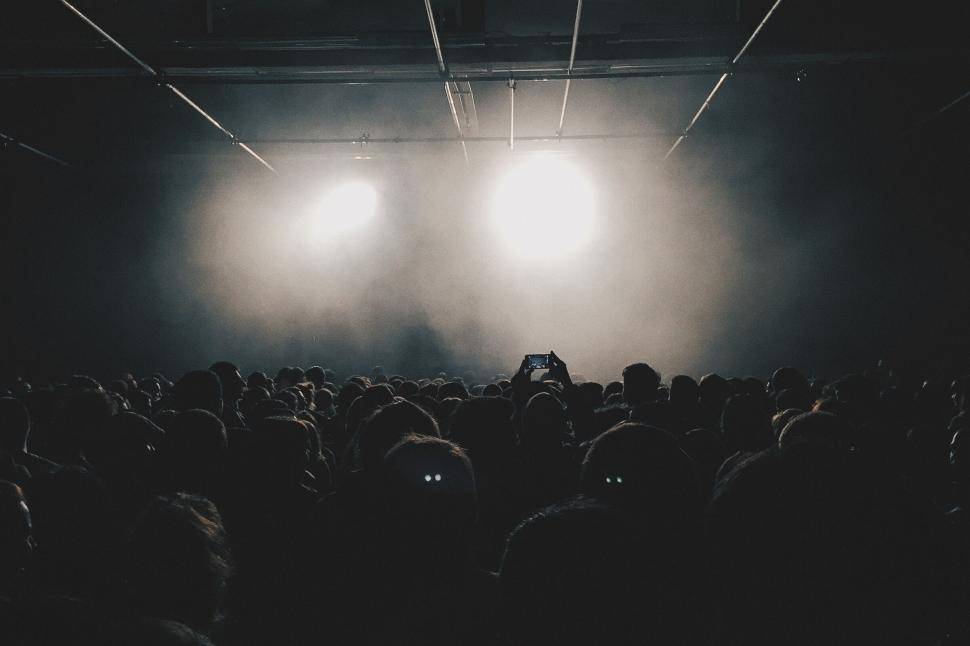 Free Image of Crowd watching a concert under bright lights 