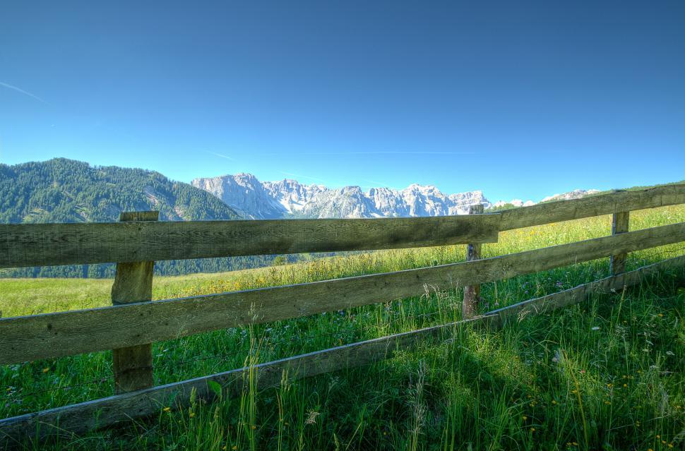 Free Image of Mountain view with wooden fence in foreground 