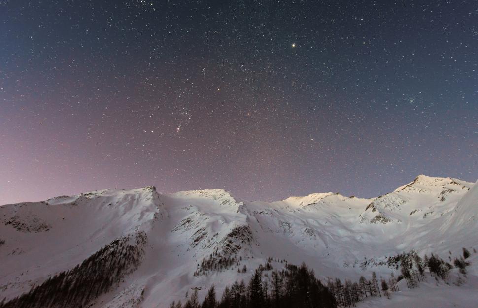 Free Image of Starry night over snowy mountains 