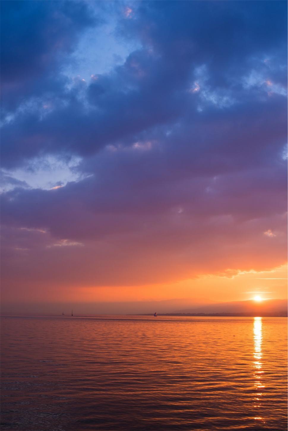 Free Image of Sunset over the ocean with colorful clouds 