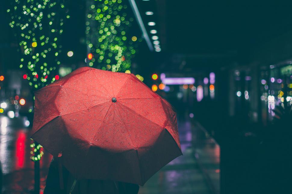 Free Image of Rainy night with a red umbrella on city street 