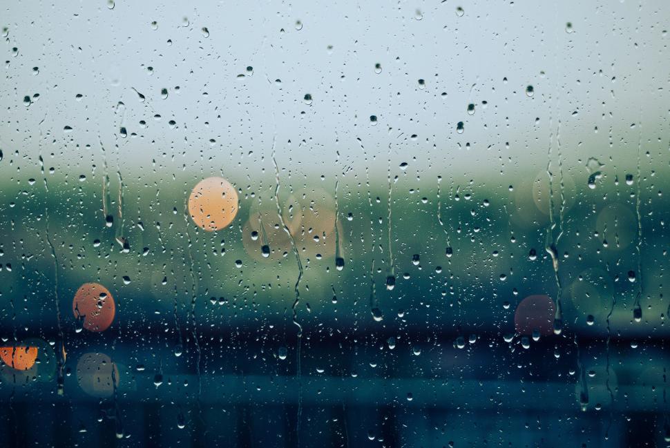 Free Image of Raindrops on a window with blurred background 