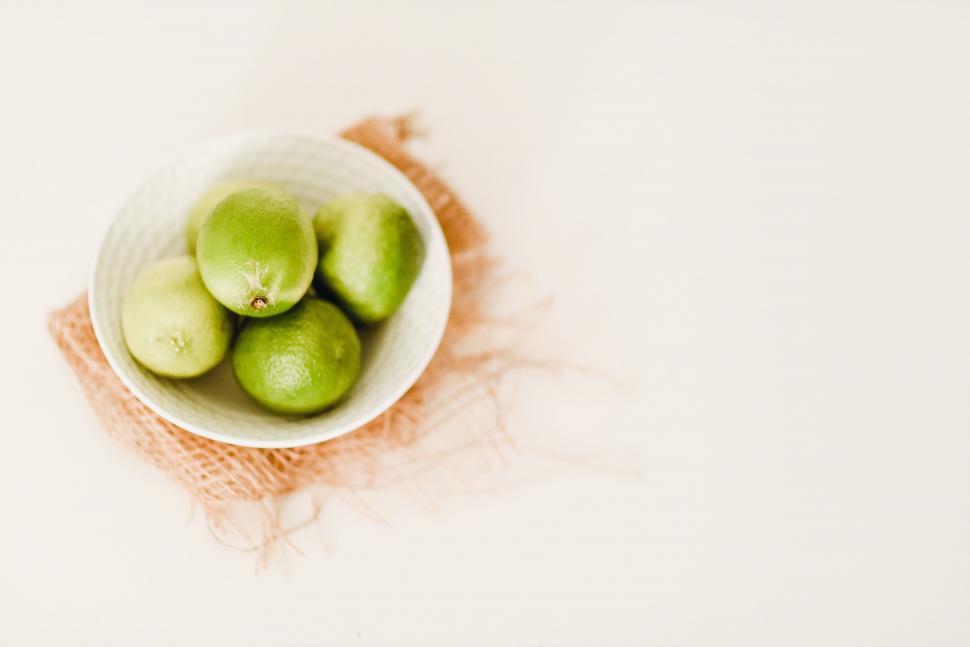 Free Image of Bowl of green limes on white background 