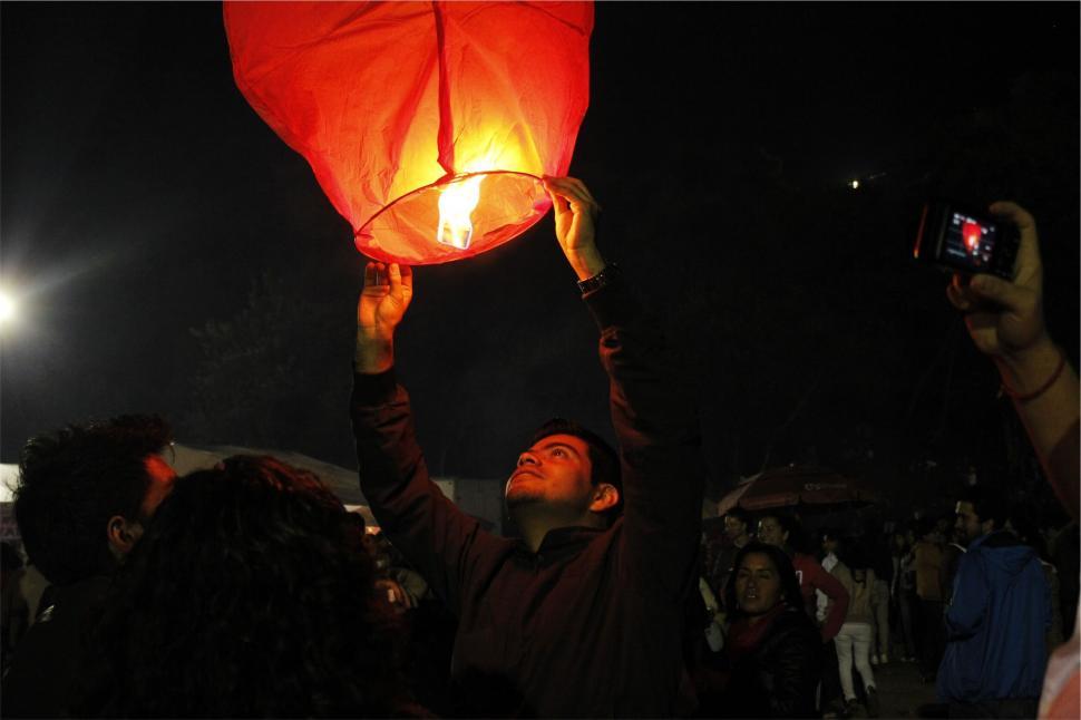 Free Image of Person releasing sky lantern at night 