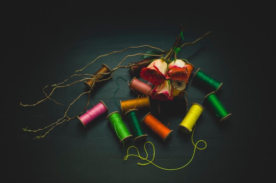 Free Image of Colourful threads and roses on dark wood 