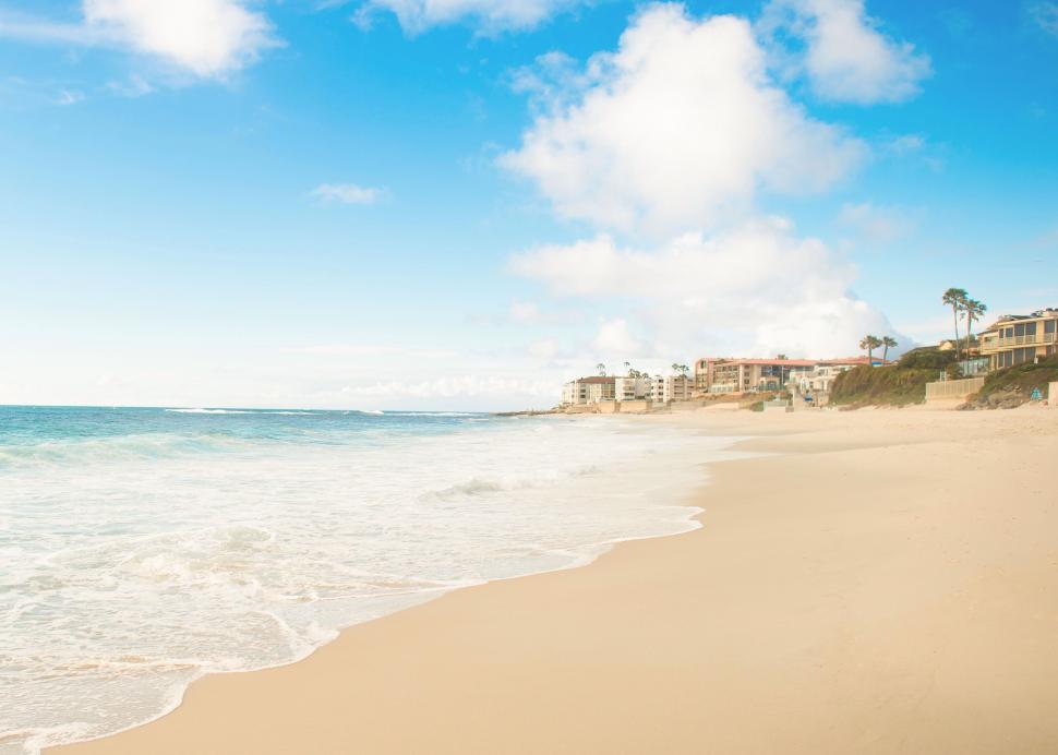 Free Image of Sunny beach with ocean and residences 