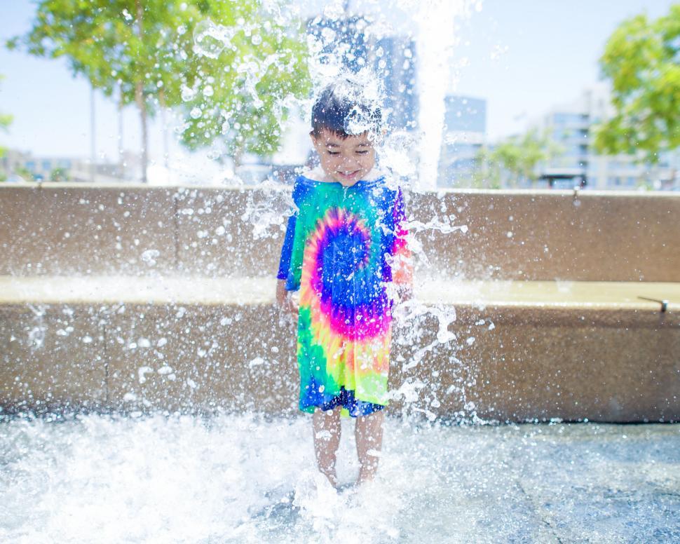 Free Image of Child playing in water fountain splash 
