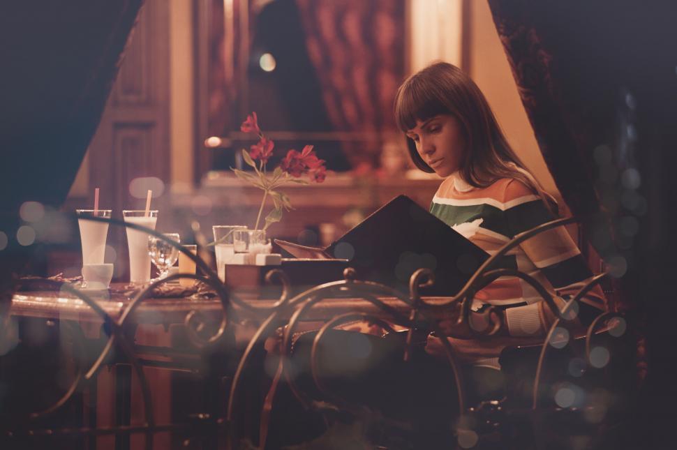 Free Image of Woman reading the menu in a cozy caf? 